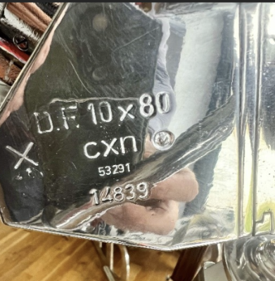 Close-up of a chrome reflector with stamped numbers: OF 10x80, cxn, 53291, 14839.